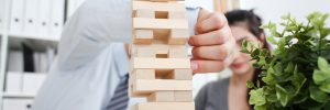 Businessman and businesswoman plays in strategy hand rearranging wooden blocks